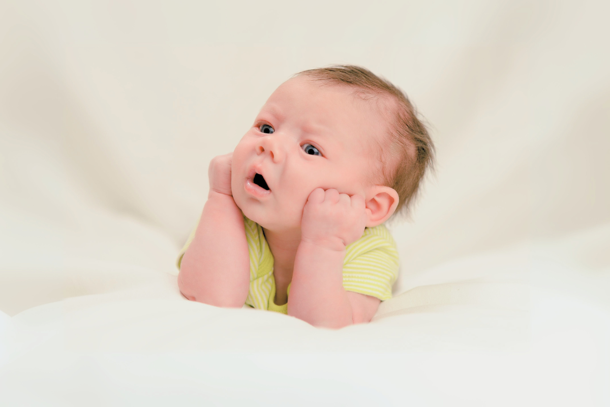 Infant holds up head with hands. Poppyseed Play