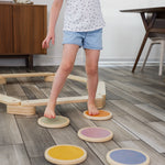 Children walking across a path of wood stepping stones.