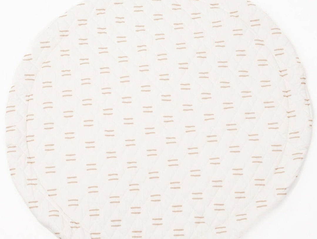 Infant lying comfortably on a thick, padded play mat with educational shapes and textures.