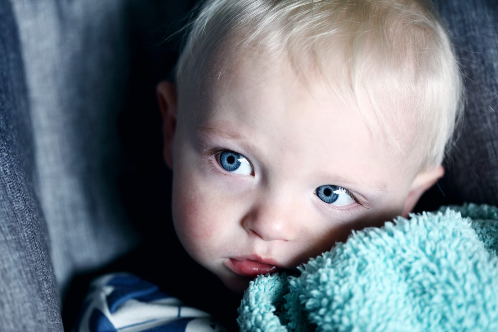 Baby Boy holding blanket. Eyesight in infants. Poppyseed Play