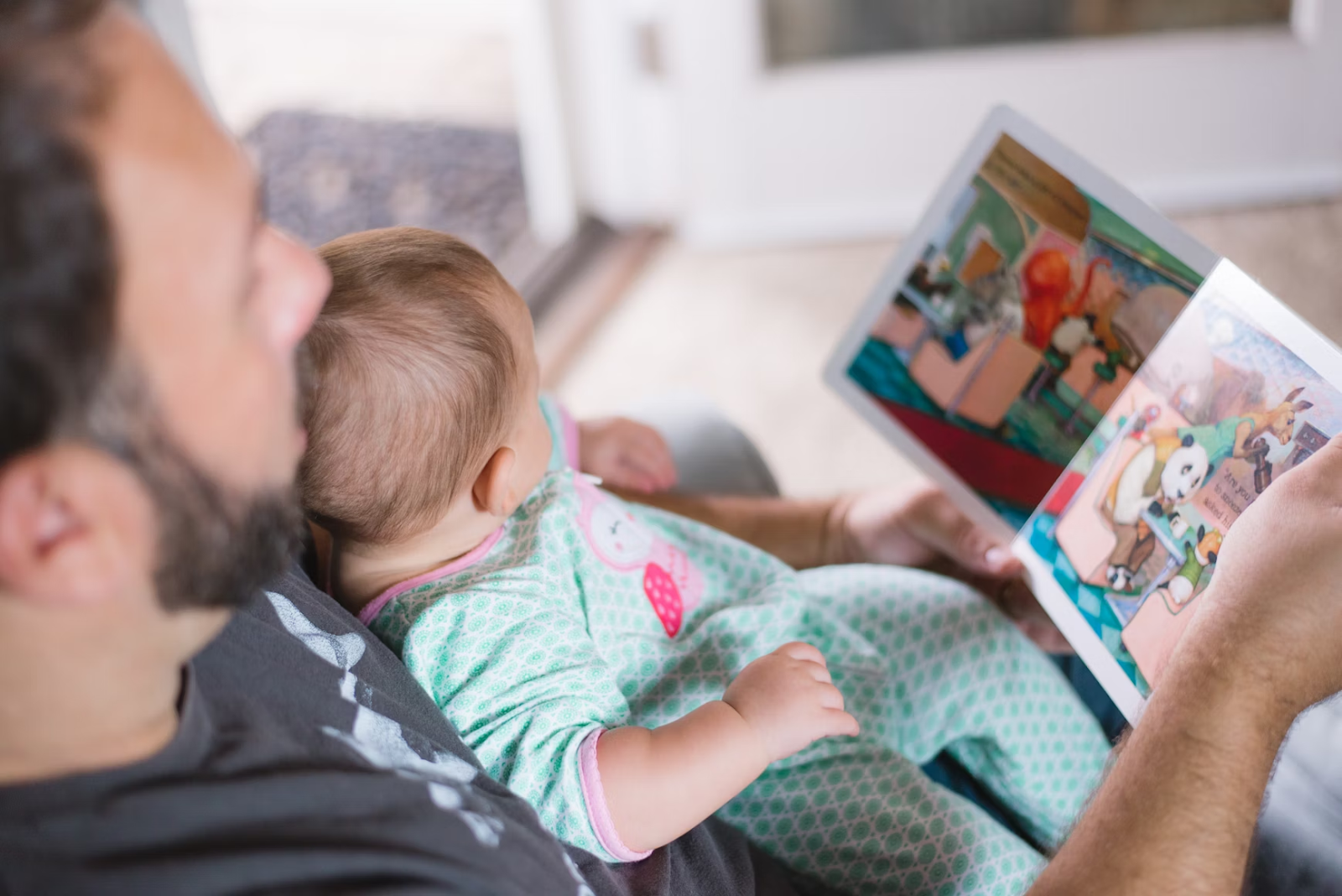 When can newborns see color? Poppyseed Play. Dad and Infant reading book 