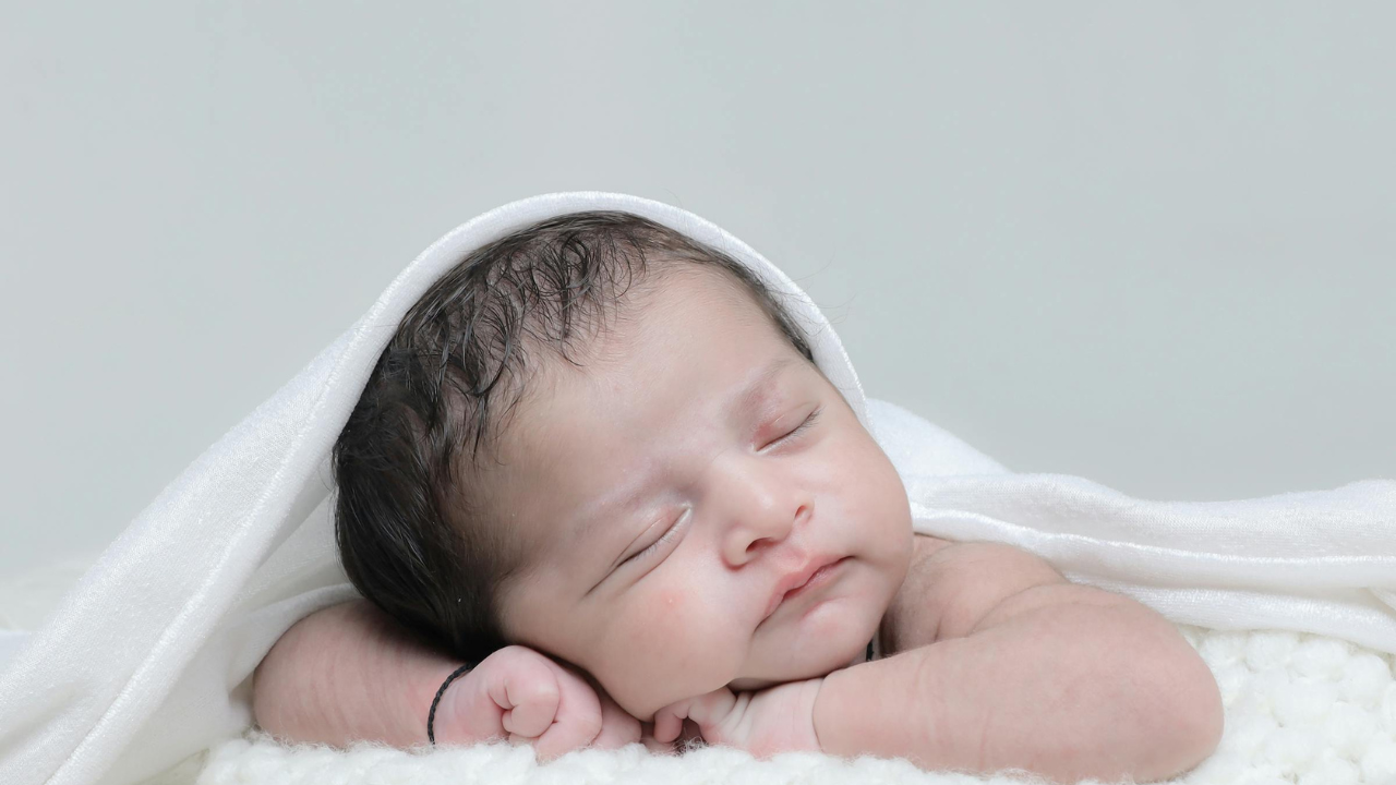 1 month old baby laying on play mat