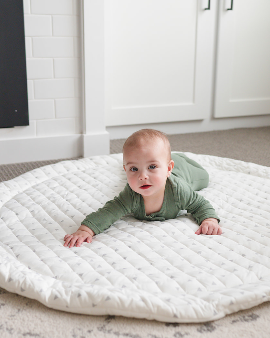 Baby practicing tummy time on the quilted Printed Round Baby Play Mat	