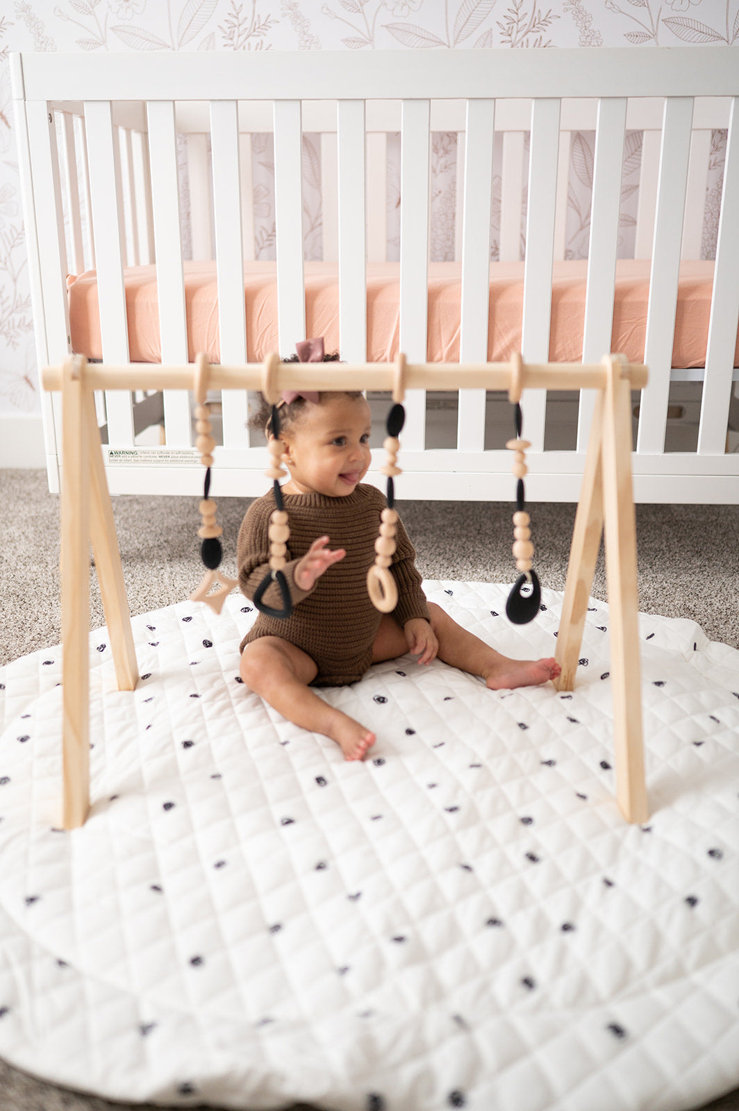 Child playing with a wooden baby gym in a nursery