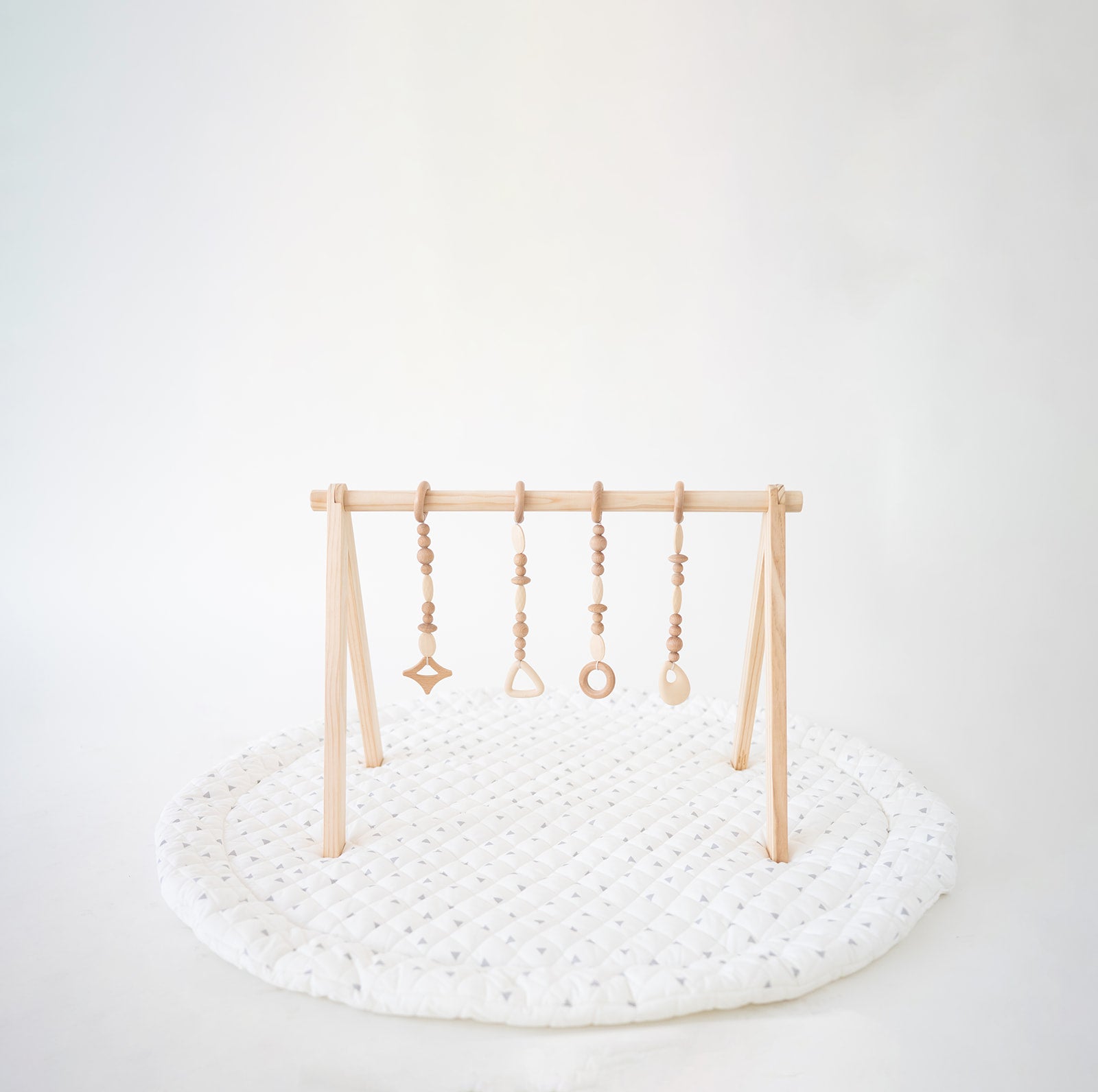 Wooden baby play gym with hanging toys on a white background