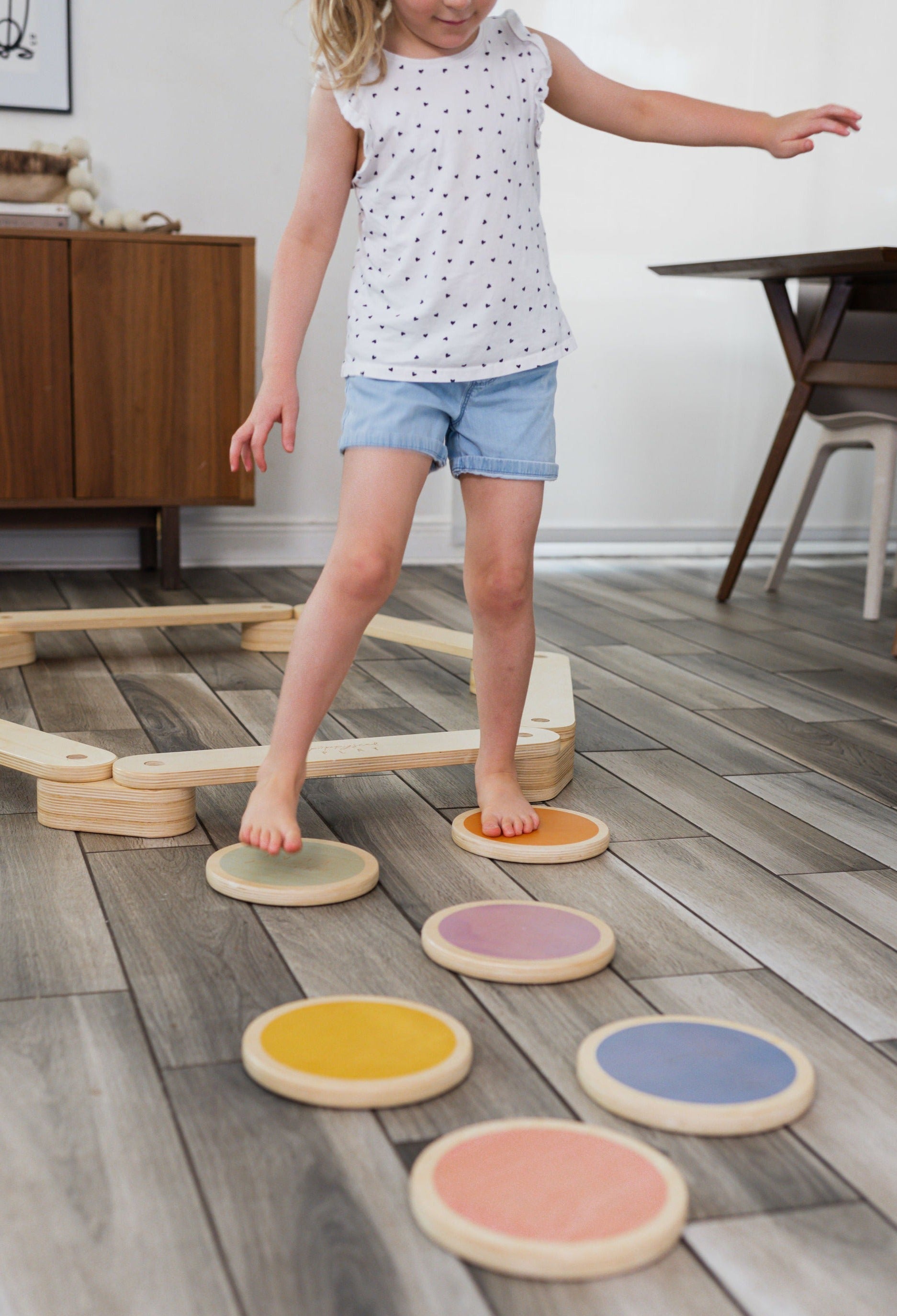 Children walking across a path of wood stepping stones.