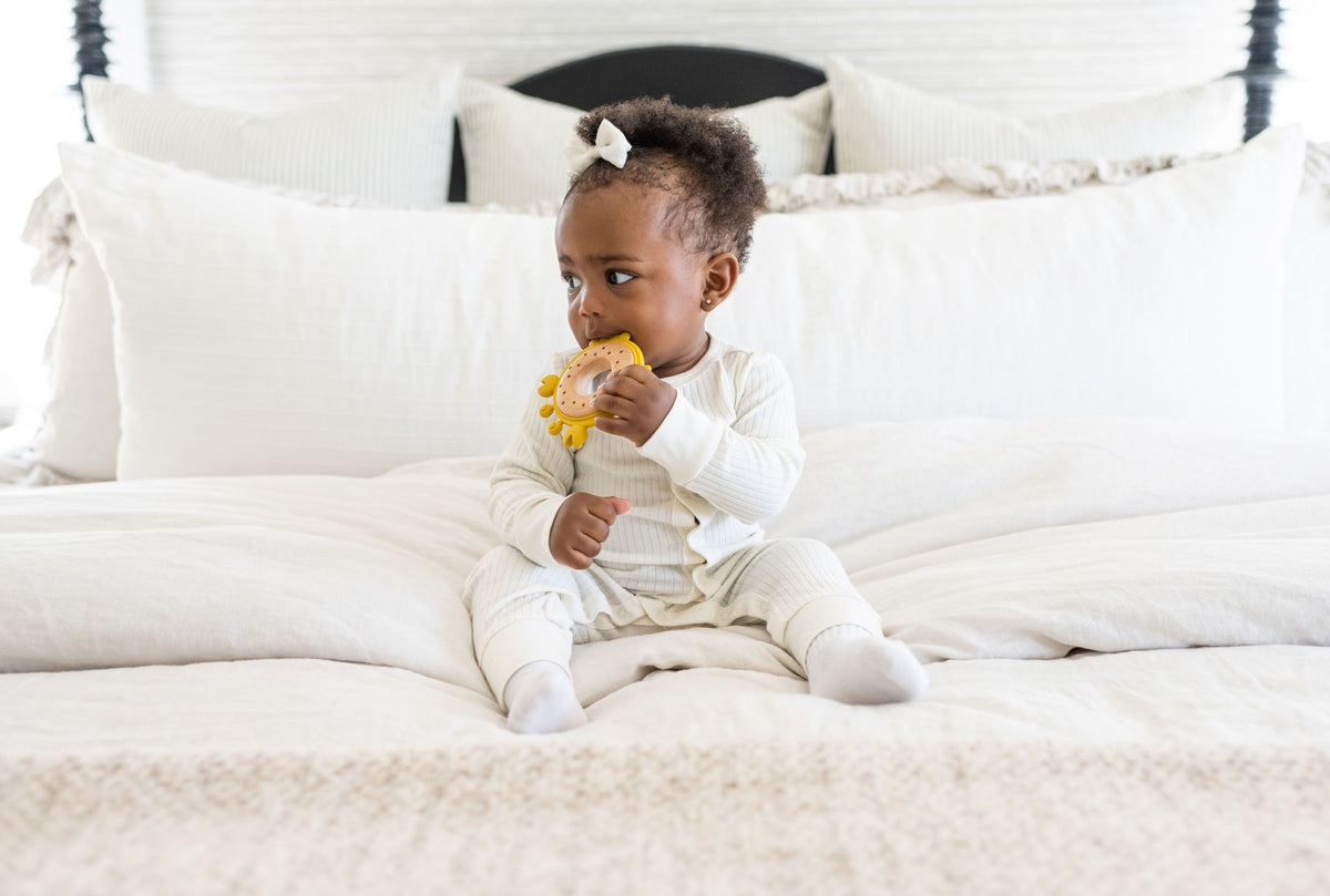 Front view of the yellow crab teether, showing its playful design with silicone legs and wooden shell