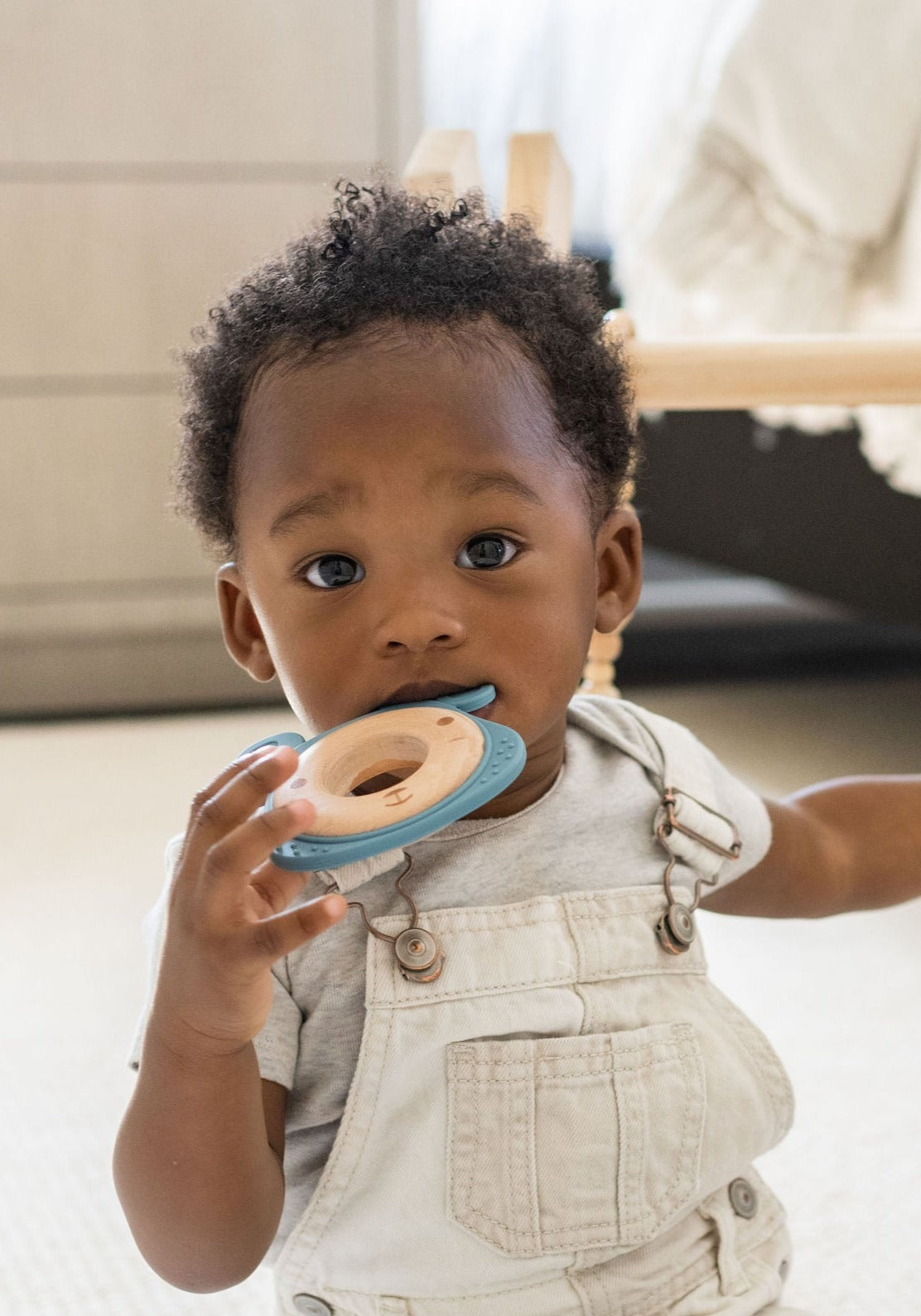 Detailed image of a silicone and wood teether with ergonomic design for easy grasping and teething relief