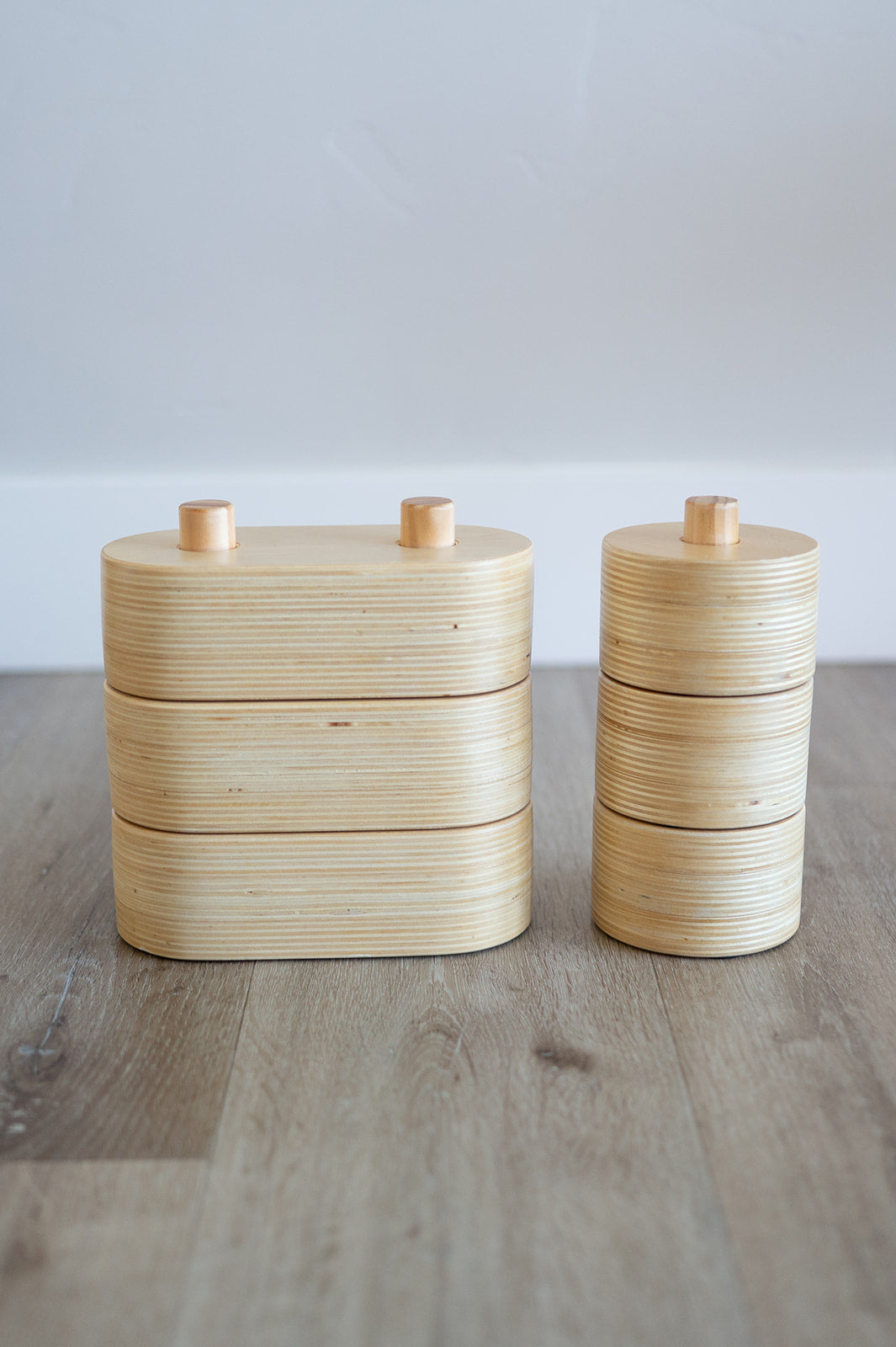 Two wooden containers with lids on a wooden surface
