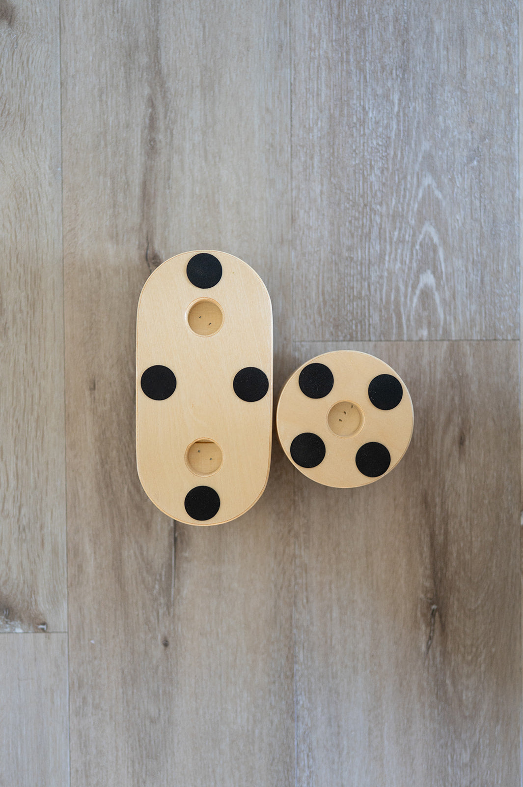 Wooden toys with black spots on a wooden surface