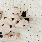 Baby reaching for high-contrast black and white toys on a stylish, modern play gym set.