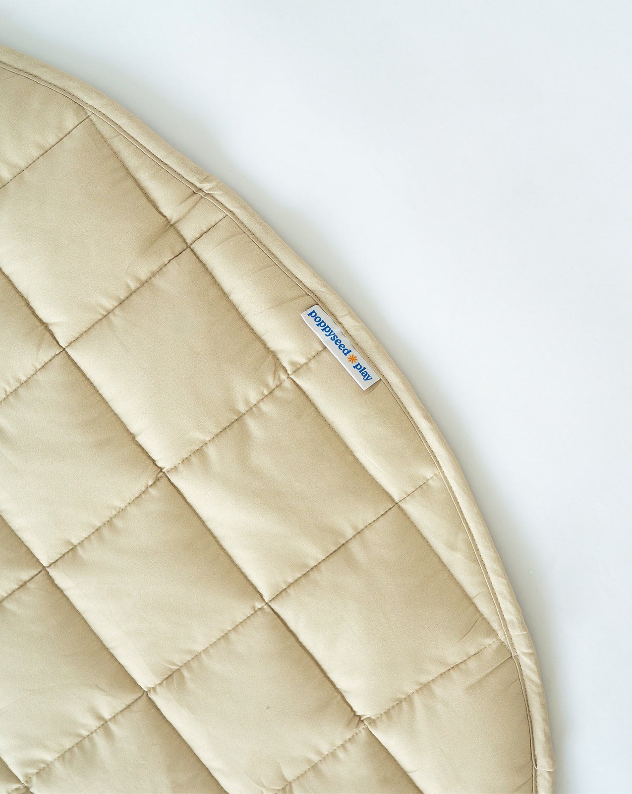 Bound edge and sewn-in tag on the Neutral Round Baby Play Mat