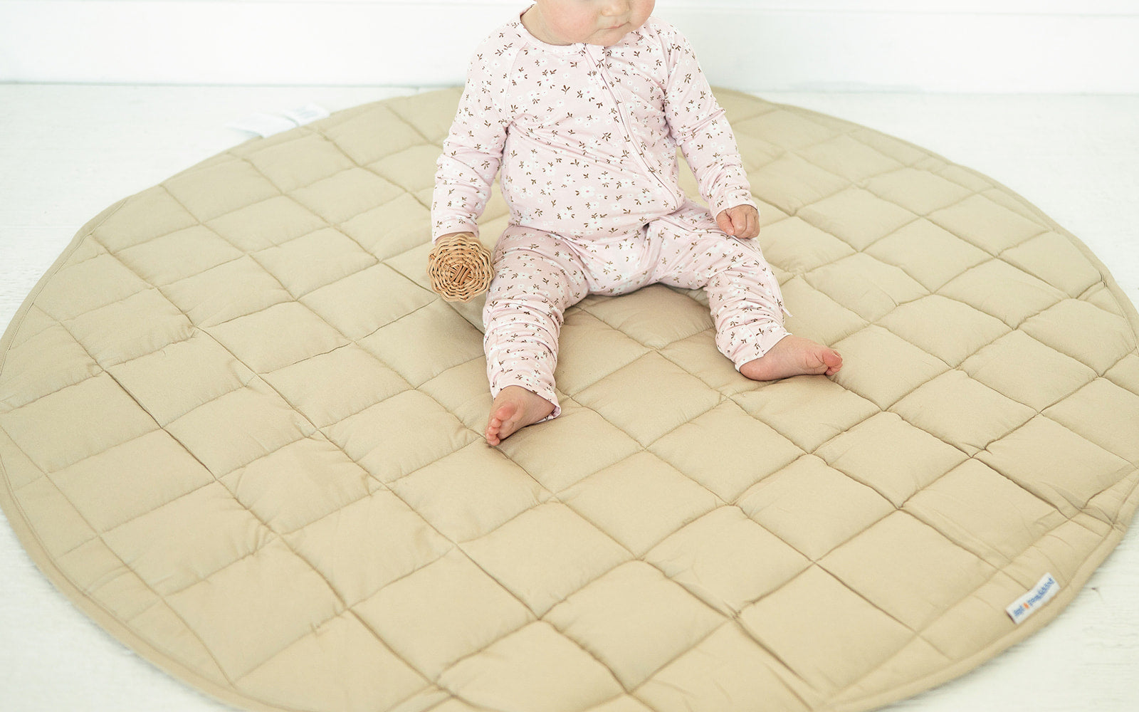 Baby sitting on the Neutral Round Baby Play Mat in taupe