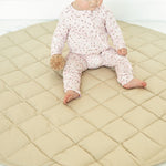 Baby sitting on the Neutral Round Baby Play Mat in taupe
