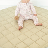Baby sitting on the Neutral Round Baby Play Mat in taupe